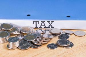 Folder Tax documents and stack of coin, concept Annual tax payment at work office photo