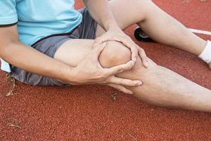 Tendon knee joint problems on Man leg from exercise In the stadium. photo