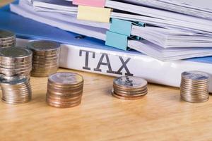 Folder Tax documents and stack of coin, concept Annual tax payment at work office photo