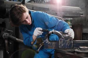 One professional young female industry engineer worker works in a safety uniform with metalwork precision tools, mechanical lathe machines, and spare parts workshop in the steel manufacturing factory. photo