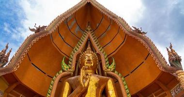 kanchanaburi, tailandia - 12 de junio de 2021 primer plano gran angular de la estatua dorada de buda de la gran bendición en el templo wat tham sua foto