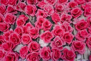 rosas rosas artificiales hechas de tela decoradas en tablero de madera foto