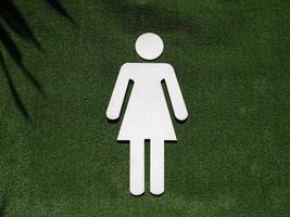 símbolo de baño femenino en hierba verde falsa foto