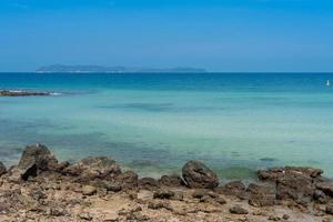 playa de arena de rocas con un paisaje marino azul claro, vistas tranquilas y relajadas al paisaje marino foto