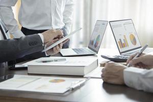 Businessmen or analysts in a meeting room reviewing and discuss on financial statements for a return on investment photo