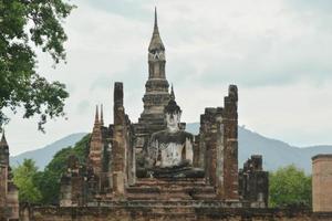 Main buddha statue and Phum Khao Bin Pagoda in Wat Maha That at the Historical Park in Sukhothai. photo