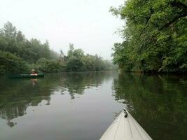 kayak in river water with green trees photo