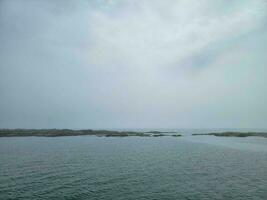 rocky shore on the coast in Maine with water and clouds photo