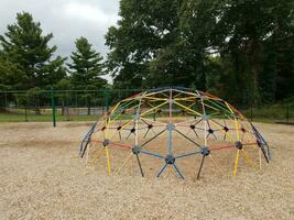 colorful metal jungle gym on playground with wood chips photo