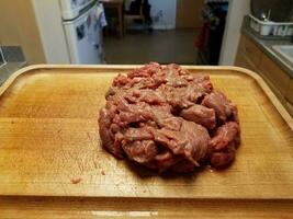raw beef on wood cutting board in kitchen photo