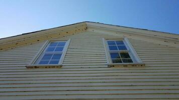 house siding with windows and mud wasp nests photo