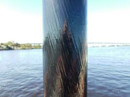 black metal pole or post with water and bridge photo