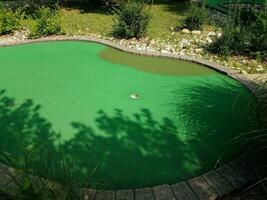 hole on miniature golf course with green artificial grass photo