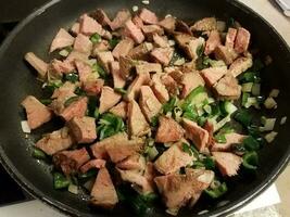 beef and hot peppers and onions in frying pan photo