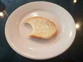 bitten bread on a white plate photo