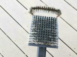 black metal wire brush to clean barbeque grill and wood photo