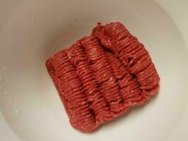 carne de res molida roja en un tazón blanco foto