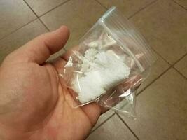 hand holding plastic bag with white salt photo