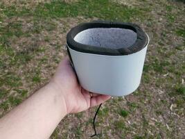 hand holding water spigot insulation cap or cover over grass photo