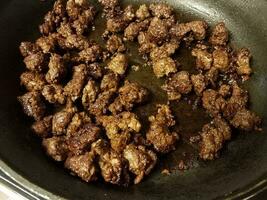 ground beef cooking in frying pan with oil photo
