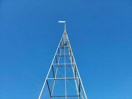 torre o estructura metálica alta con bandera azul y blanca foto