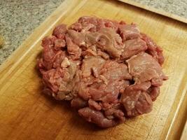 carne cruda en tabla de cortar de madera en el mostrador foto