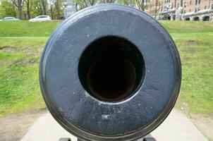large circular hole in black metal cannon weapon