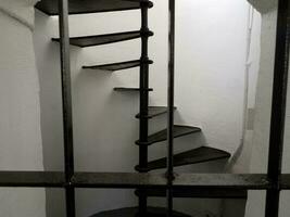 black iron spiral staircase with white walls in lighthouse photo