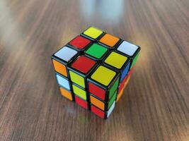 colorful cube of squares on brown wood table photo