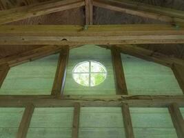 interior of wood building with wooden boards or studs and circular window photo