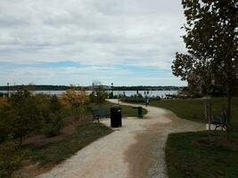 child running in park on trail near river and bridge photo