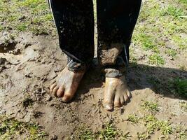 child with muddy feet and mud and grass photo