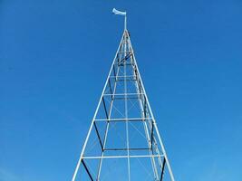 tall metal tower or structure with blue and white flag photo