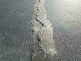 black asphalt with black caulk line to repair crack photo