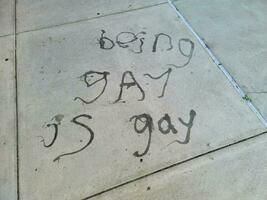 being gay is gay written on tiles on the ground photo