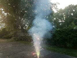lit colorful fireworks on asphalt driveway with smoke photo