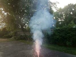 lit colorful fireworks on asphalt driveway with smoke photo