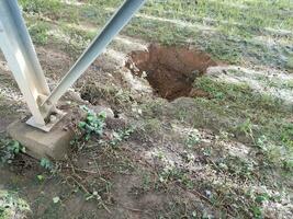 large hole in the dirt and metal structure photo