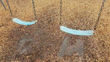 blue seat on swing with water puddle and mulch photo