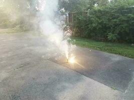 lit colorful fireworks on asphalt driveway with smoke photo