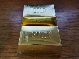 gold bars or blocks on wood desk or surface photo