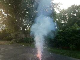 lit colorful fireworks on asphalt driveway with smoke photo