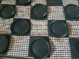 black plastic checkers on fabric board photo