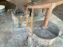 heavy metal anvil and large rusty paperclip photo