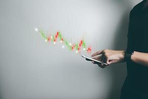 Investor is trading stock with smartphone, trader analyze stock price with candlestick chart, business growth, currency exchange, economic progress, finance with internet technology. photo