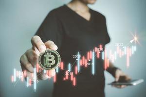 Cryptocurrency Investor holding bitcoin, analyzing graph with smartphone, businessman forecast growth of Blockchain technology, future of financial, Decentralized financi DeFi, Global Economy. photo