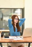 Woman stretches her arms when tired in the office, business woman relaxes, office syndrome. photo