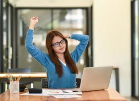 Woman stretches her arms when tired in the office, business woman relaxes, office syndrome. photo