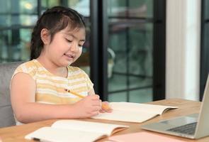 las chicas asiáticas están estudiando en tutoría, estudiando en línea en casa, las chicas están aburridas y cansadas de la tutoría. foto