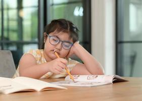 Asian girls are studying in tutoring, studying online at home, girls are bored and tired from tutoring. photo